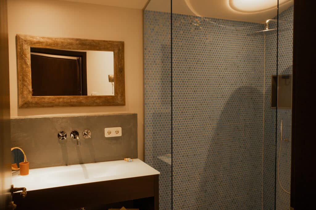 Jedes Chalets hat ein modernes Badezimmer. Ein besonderes Detail bilden die mosaikartigen Fließen in der Regendusche